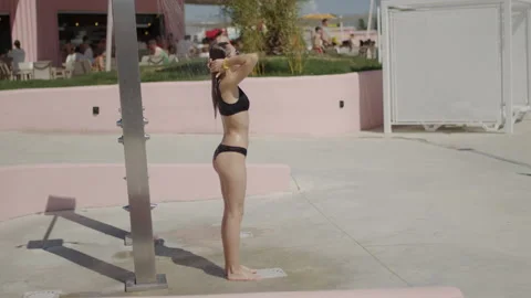 Young beautiful sexy tanned woman in bikini taking summer shower on pool sea Stock Footage