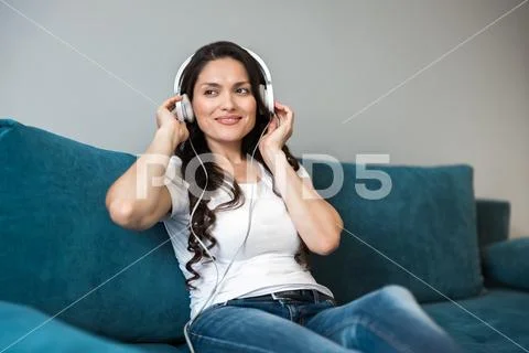 Young beautiful smiling woman in headphones listening to her favourite music in Stock Photos