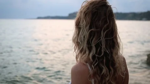 Young beautiful standing on a beach at sunset Stock Footage 73994786