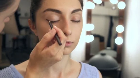 Young beautiful woman applying make-up by make-up artist Stock Footage 77781753