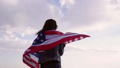 Young beautiful woman with black hair holding a USA flag Stock Footage