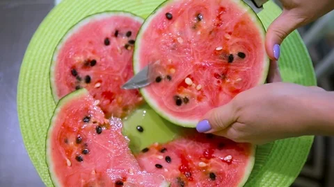Young beautiful woman cuts with knife watermelon on a table. Stock Footage 114185553