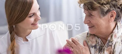 Young Beautiful Woman In A Duster And Her Lovely Elderly Patient In A Nursing Ho