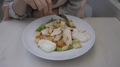 Young beautiful woman eats caesar salad in a cafe Stock Footage 102346906