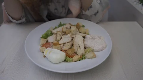 Young beautiful woman eats caesar salad in a cafe Stock Footage 102347005