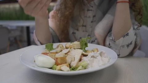 Young beautiful woman eats caesar salad in a cafe Stock Footage 102347191