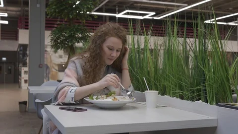 Young beautiful woman eats caesar salad in a cafe Stock Footage 102347264