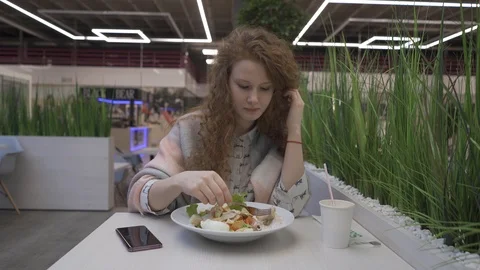 Young beautiful woman eats caesar salad in a cafe Stock Footage 102347471