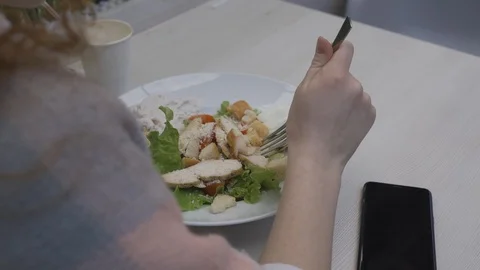 Young beautiful woman eats caesar salad in a cafe Stock Footage 102347555