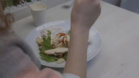 Young beautiful woman eats caesar salad in a cafe Stock Footage 102347603