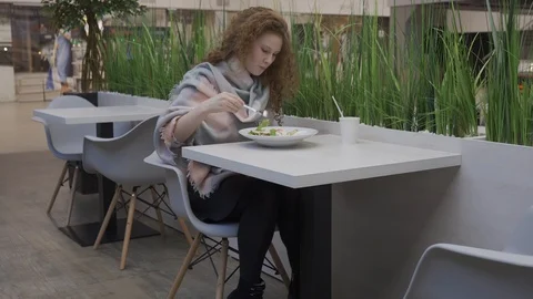 Young beautiful woman eats caesar salad in a cafe Stock Footage 102347802
