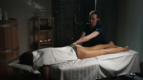 Young beautiful woman gets body massage in spa salon. Naked lady perfect skin. Stock Footage
