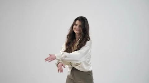 Young beautiful woman posing while dancing against a white wall in the studio Stock Footage 244894149