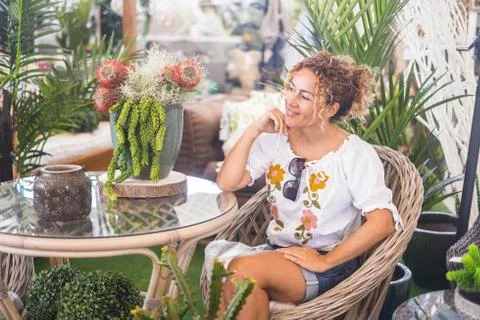 Young beautiful woman sit down in a garden nature store - gardening and home  Stock Photos