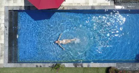 The young beautiful woman swims in the pool, flat lay, dron view... Stock Photos