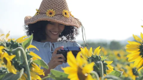 Young beautiful woman using camera to take sunflowers photo. Video stock 168076453