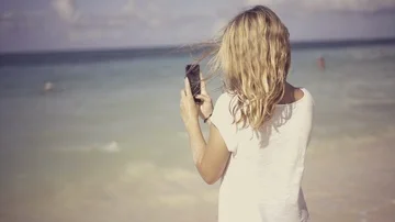 Young, beautiful woman using her phone at the beach and taking pictures Stock Footage 85599288