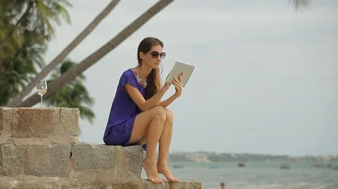 Young beautiful woman using a tablet computer at the seaside. Stock Footage 44973987