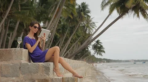 Young beautiful woman using a tablet computer at the seaside. Stock Footage 44974184