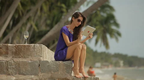 Young beautiful woman using a tablet computer at the seaside. Stock Footage 55094891