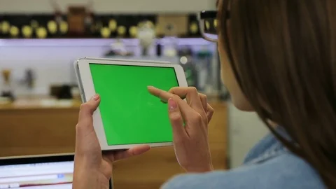 Young beautiful woman using tablet with green screen sitting in the cafe, swipe Stock Footage 72361273