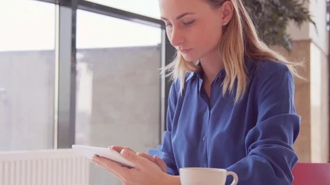 Young, beautiful woman using tablet and drinking tea in the cafe 스톡 동영상 73363206