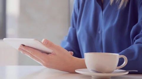 Young, beautiful woman using tablet and drinking tea in the cafe 스톡 동영상 73363236