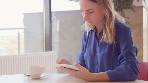 Young, beautiful woman using tablet and drinking tea in the cafe 스톡 동영상 73363267