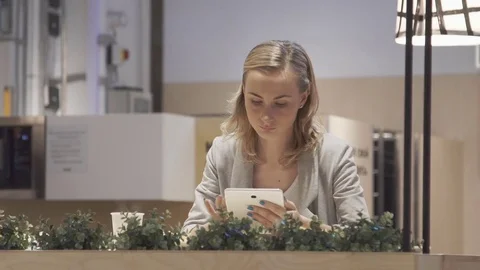 Young, beautiful woman using tablet and drinking tea in the cafe Stock Footage 78981998