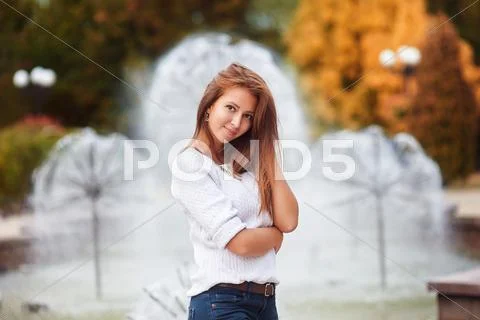 Young beautiful woman walking and posing in city near fountains Stock Photos