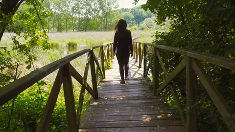 Young Beautiful Woman Walking on a Wood Bridge in the Swamp Stock Footage