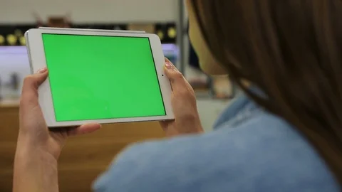 Young beautiful woman watching video on tablet with green screen in the cafe Stock Footage