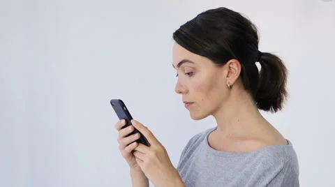Young beautiful woman writes an SMS to her mobile phone Stock Footage