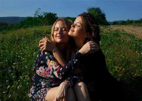 Young beautiful women huging standing by the lake Stock Photos