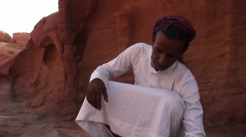 Young Bedouin man makes fire in desert Stock Footage 8723628