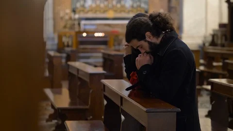 Young believing couple silently prays in church.God, Faith, religion Stock Footage 119985091