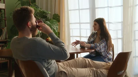 Young beloved couple sit at table chatting at home Stock Footage 266809839