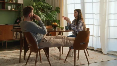 Young beloved couple sit at table chatting at home Stock Footage 266810112