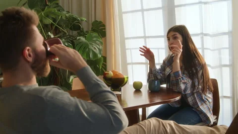 Young beloved couple sit at table chatting at home Stock Footage 266810145