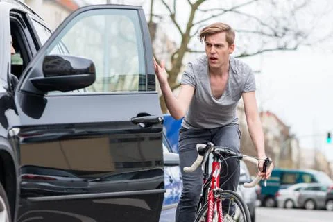Young bicyclist shouting while swerving for avoiding dangerous collision Stock Photos
