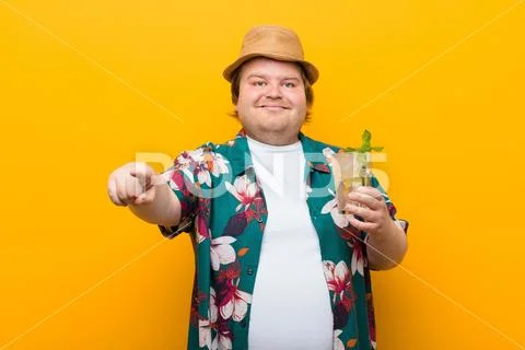 Young big size man with a mojito drink against flat wall Stock Photos