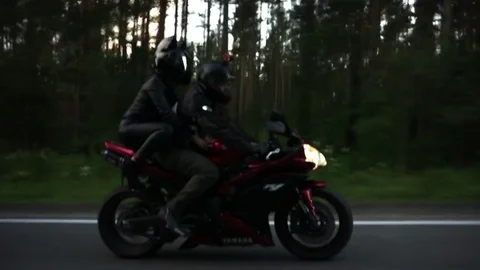 A young biker in a leather jacket and a helmet riding at the motorcycle along Stock Footage 83484926