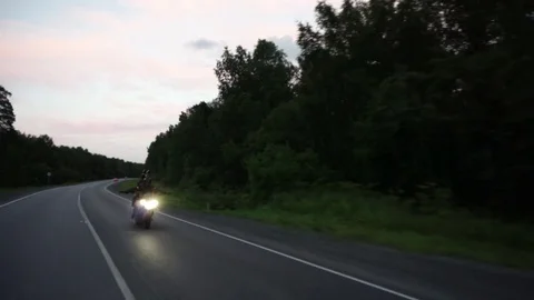 A young biker in a leather jacket and a helmet riding at the motorcycle along Stock Footage 83548871