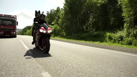 A young biker in a leather jacket and a helmet riding at the motorcycle along Stock Footage 83590889