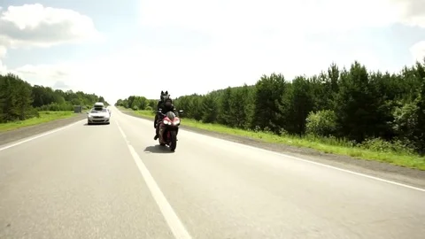 A young biker in a leather jacket and a helmet riding at the motorcycle along Stock Footage 83705517