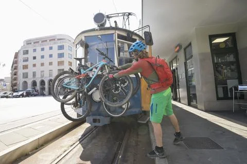 Young biker loading bikes on cable car Stock Photos