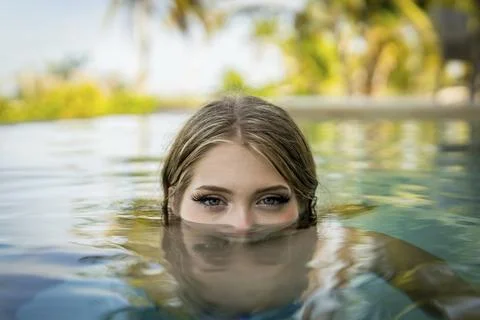 Young bikini model luxuriates in warm sun, cool pool, Yucatan Mexico vacation Stockfoto's