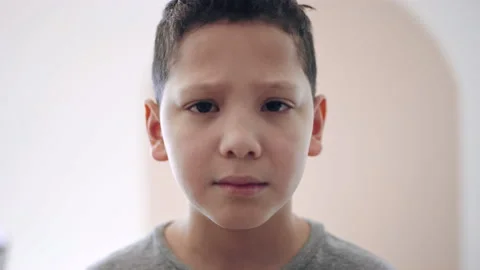 Young biracial boy looks into camera with sad, devastated, crying expression 스톡 동영상 194470671