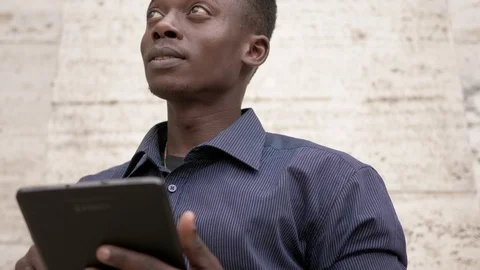 Young black american man using digital tablet in the street and looking around  스톡 동영상 92781038