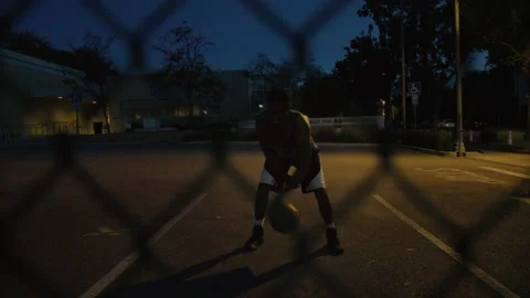 Young black basketball player train at night court Stock Footage